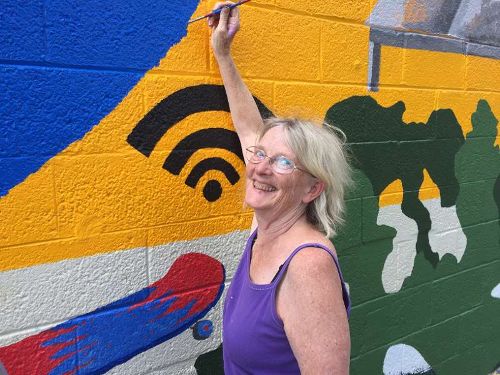 Rebecca Tippens painting the mural
